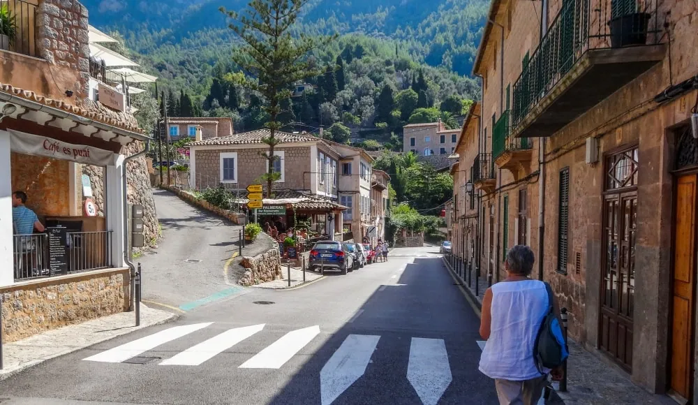 Village street with local cafés and outdoor seating in Deià