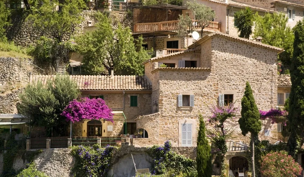 Traditional stone village houses with green shutters in Deià, Mallorca