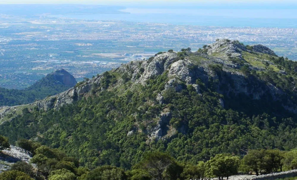 The peak of Puig des Teix rising above the village of Deià