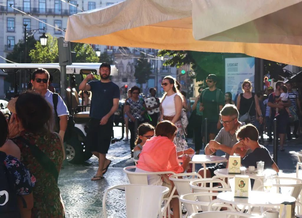 Terrasse de café animée dans une ville européenne illustrant l'expansion des iBuyers en Europe et les cycles de revente de 90 jours en Espagne.