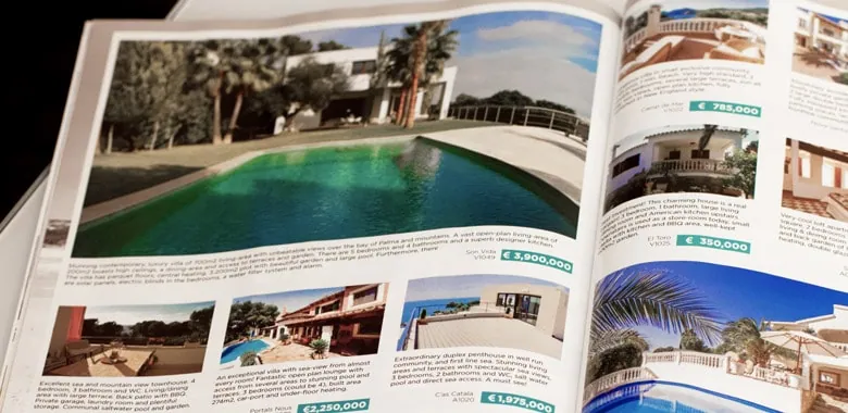 Revista de catálogo imobiliário aberta com anúncios de moradias de luxo com piscina.